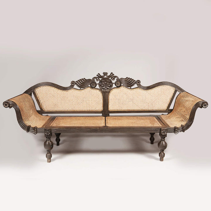 British colonial ebony sofa with carved floral details and caned seat by Collection EE20