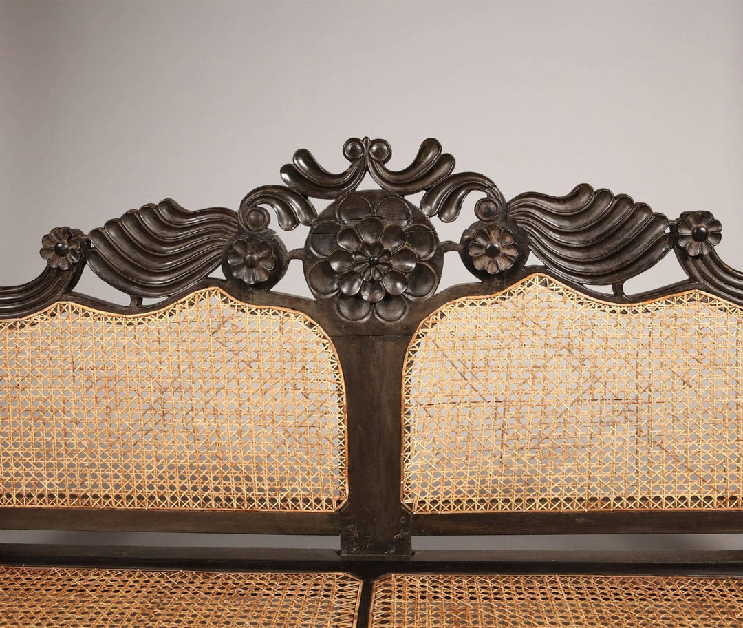Close-up of carved floral ebony crest rail and caned backrest from Collection EE20 British colonial sofa