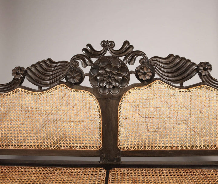 Close-up of carved floral ebony crest rail and caned backrest from Collection EE20 British colonial sofa