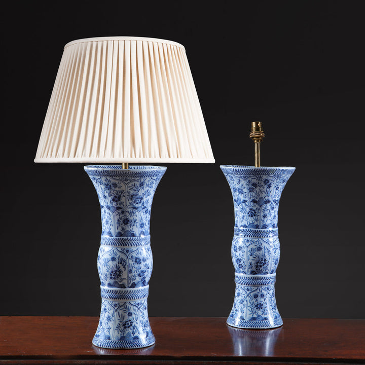 Delft Blue and White Kangxi Table Lamps pair with flared necks and blue floral patterns on white porcelain bases.