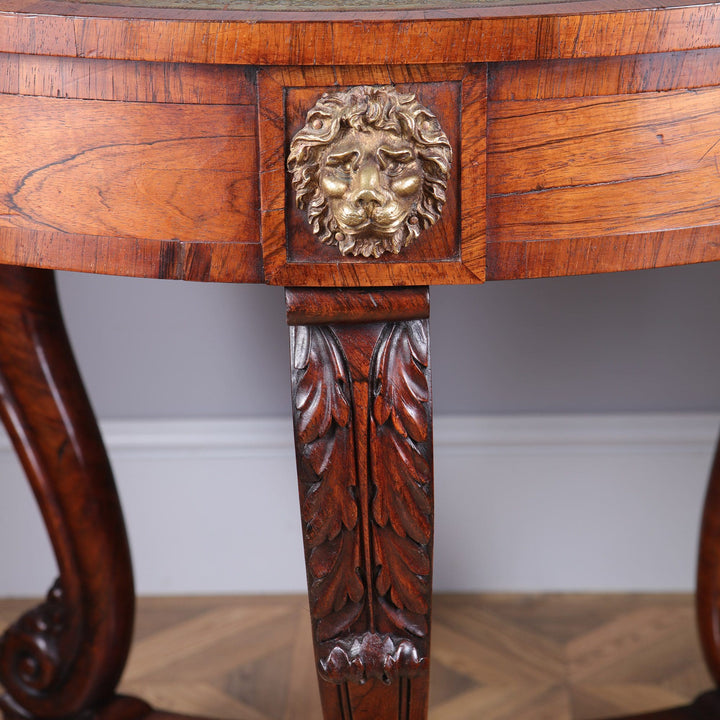 Regency Rosewood Drum Table detailed lion mask on drawer and carved scroll leg with leaf motifs in rich wood finish.