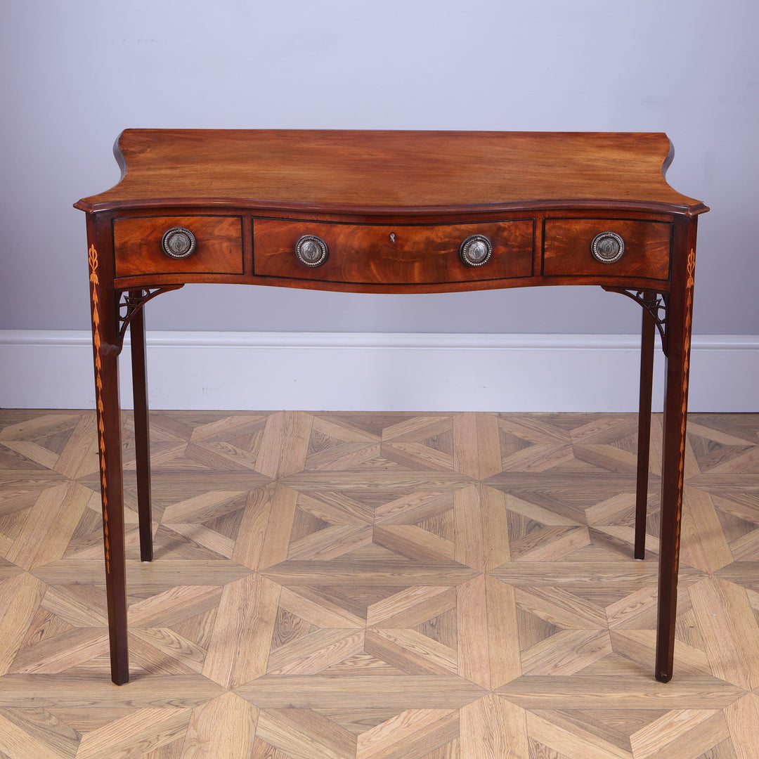 George III Hepplewhite Serpentine Side Table solid mahogany top with three drawers and silver plated ring handles.