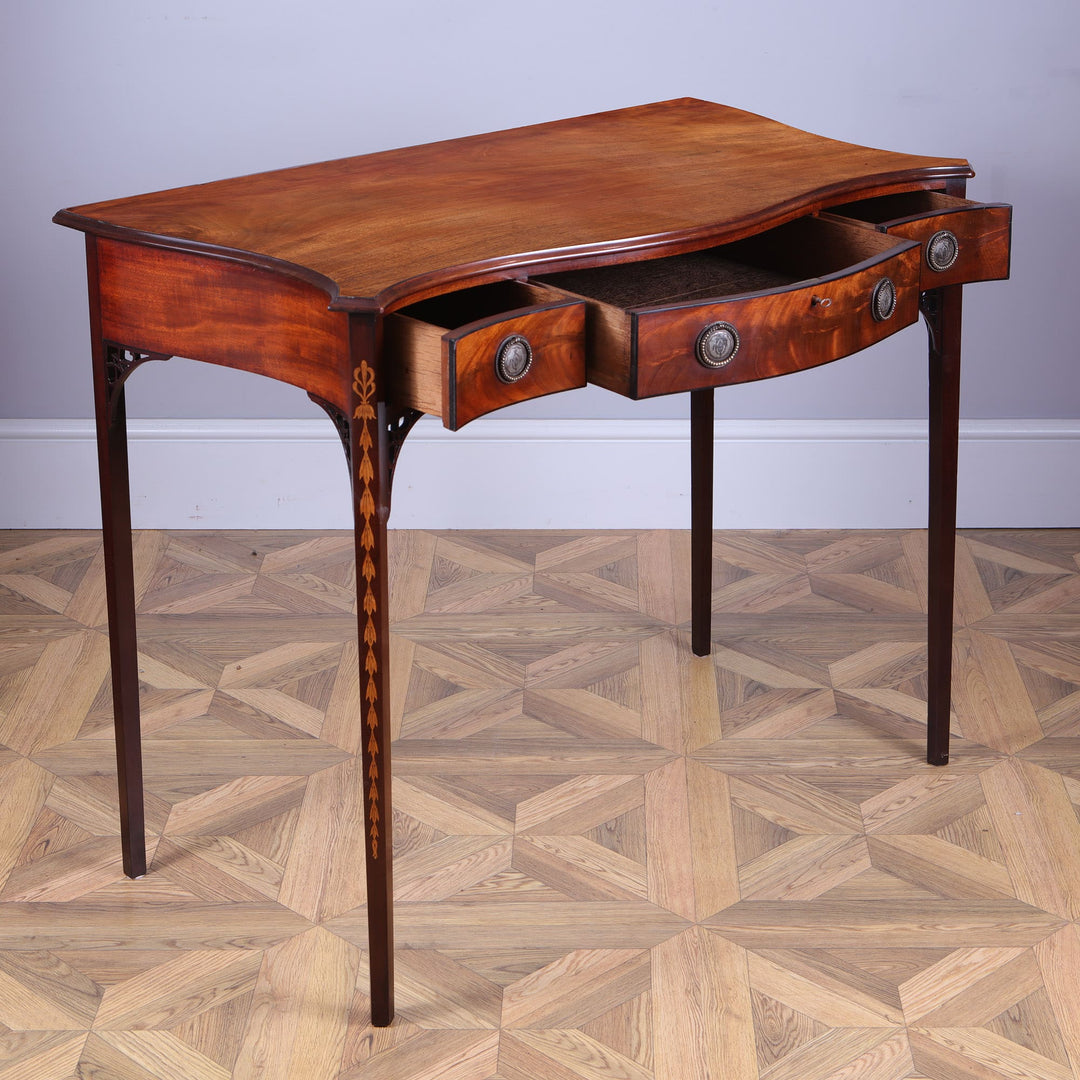 George III Hepplewhite Serpentine Side Table with three drawers, mahogany top, silver ring handles, and inlaid marquetry.