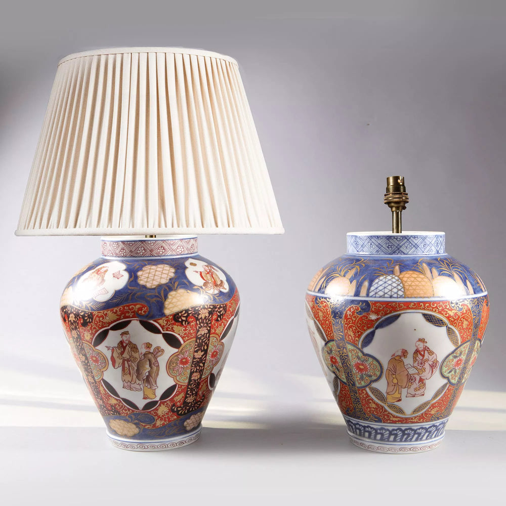 Near Pair of Japanese Imari Vases as Lamps featuring traditional porcelain design, circa 1890, one with pleated shade, one without.