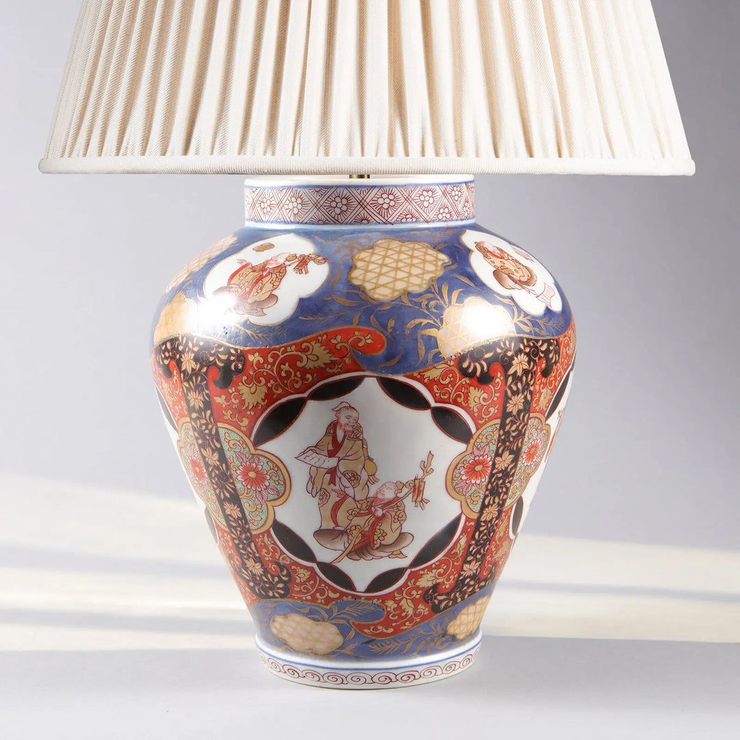 Near Pair of Japanese Imari Vases as Lamps with intricate blue red gold porcelain pattern and pleated lampshade.