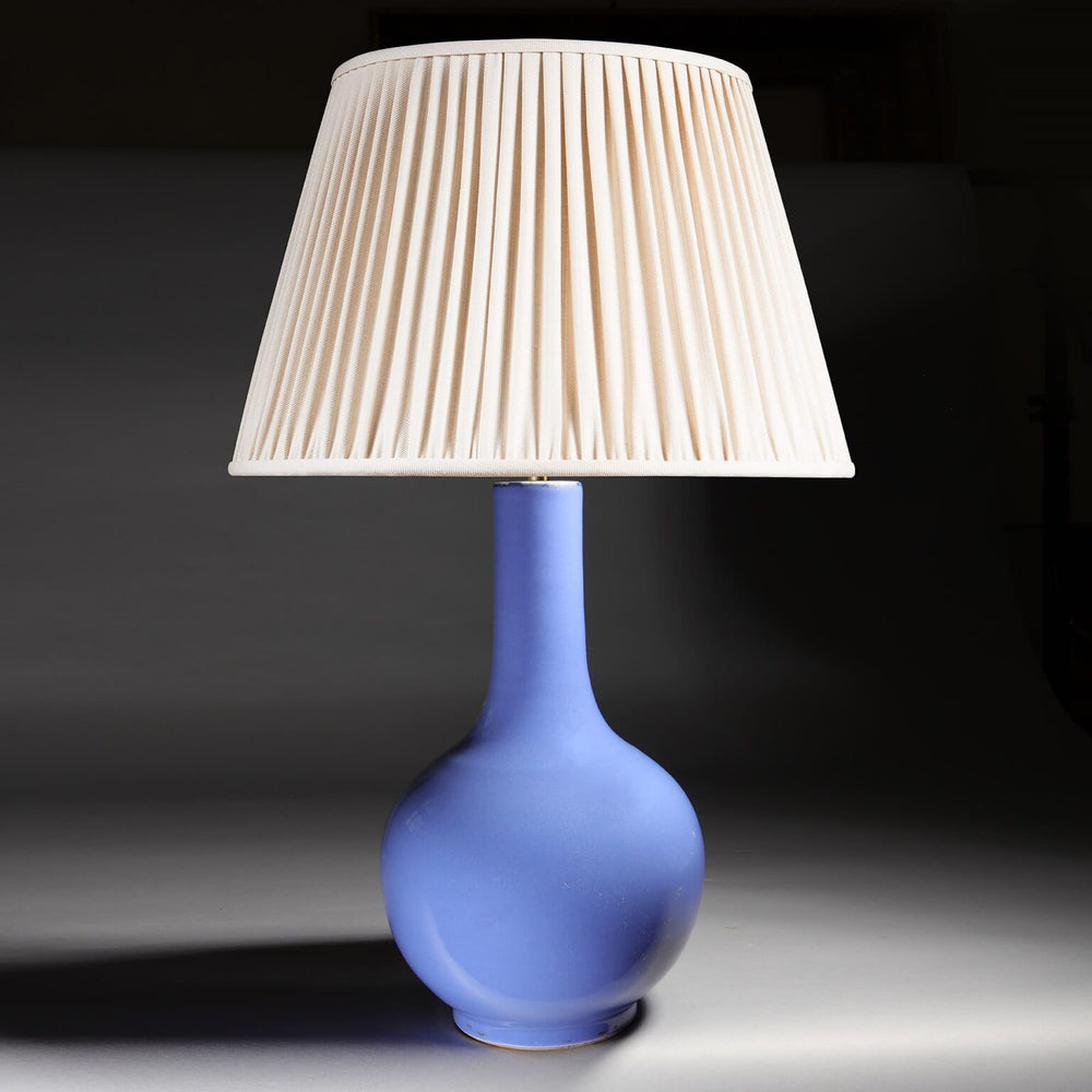 Monochrome Lilac Vase as a Table Lamp with pleated cream shade and smooth lilac porcelain base against dark background.