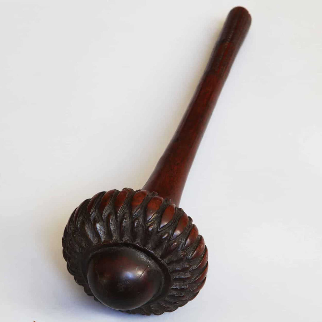 Fijian I Ula Tavatava Throwing Club made of dark polished wood with carved decorative elements on the head.