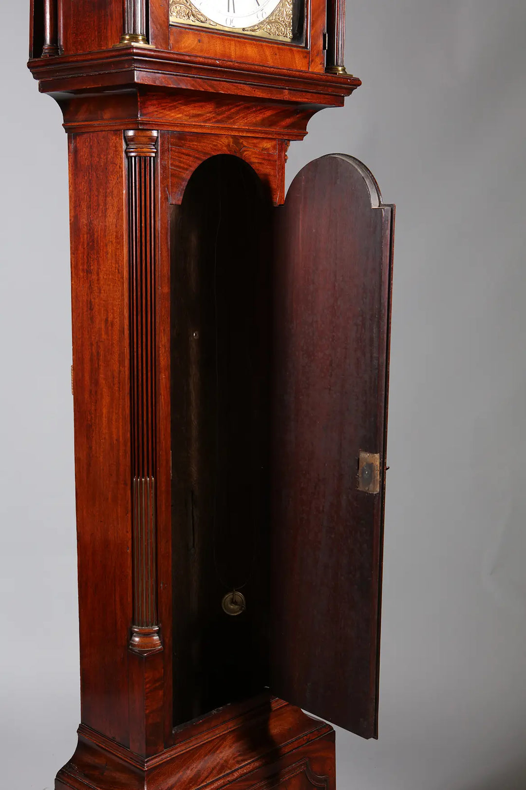 Close-up of an open George III mahogany longcase clock by Nicholas Wells Antiques showcasing fine veneers and detailed woodwork.