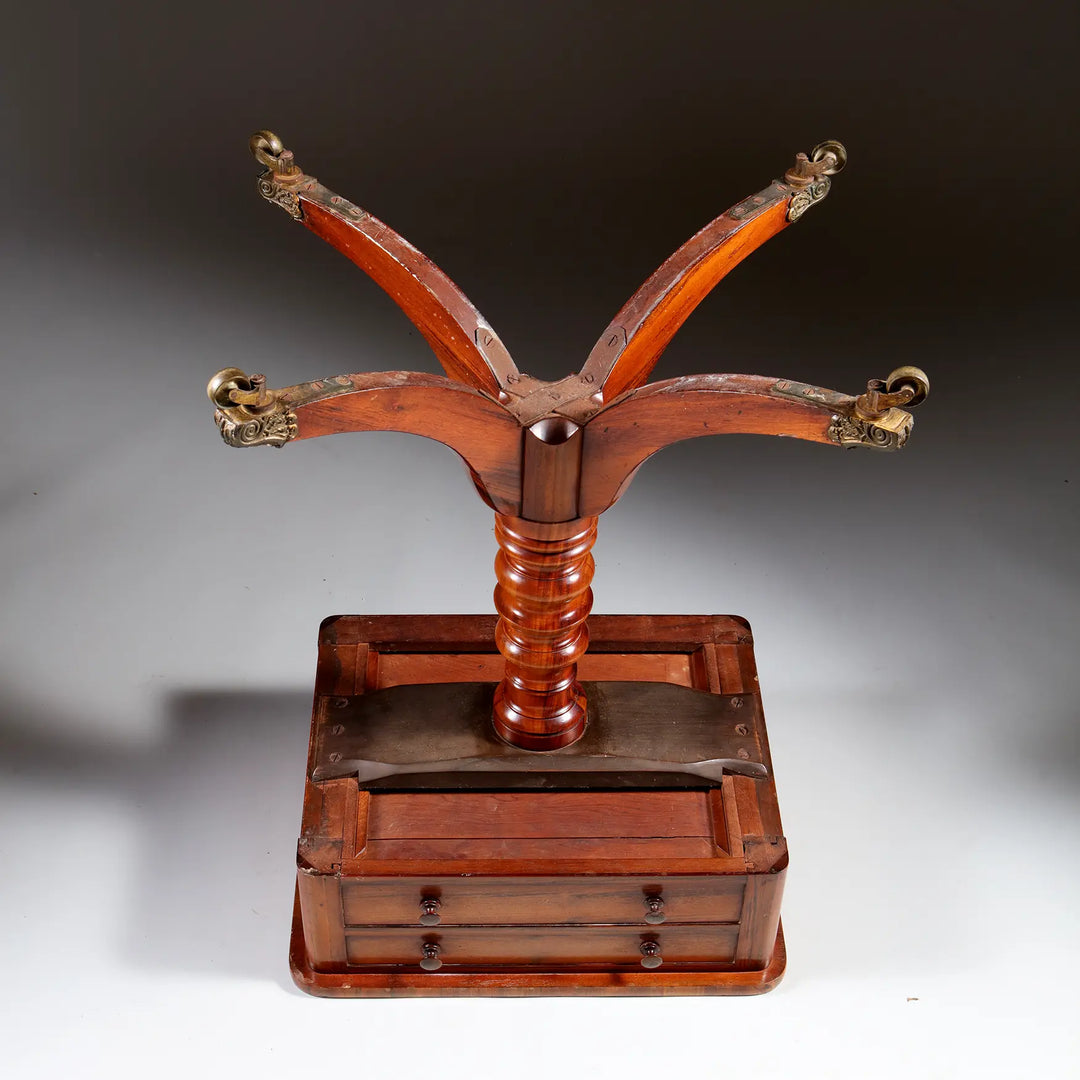 Regency Goncalo Alves Occasional Table shown upside down with wooden legs and brass casters on a plain background.