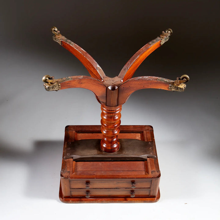 Regency Goncalo Alves Occasional Table shown upside down with wooden legs and brass casters on a plain background.