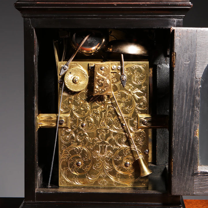 Intricately engraved gilt bronze clock mechanism inside ebony case from John Ellicott, offered by Nicholas Wells Antiques