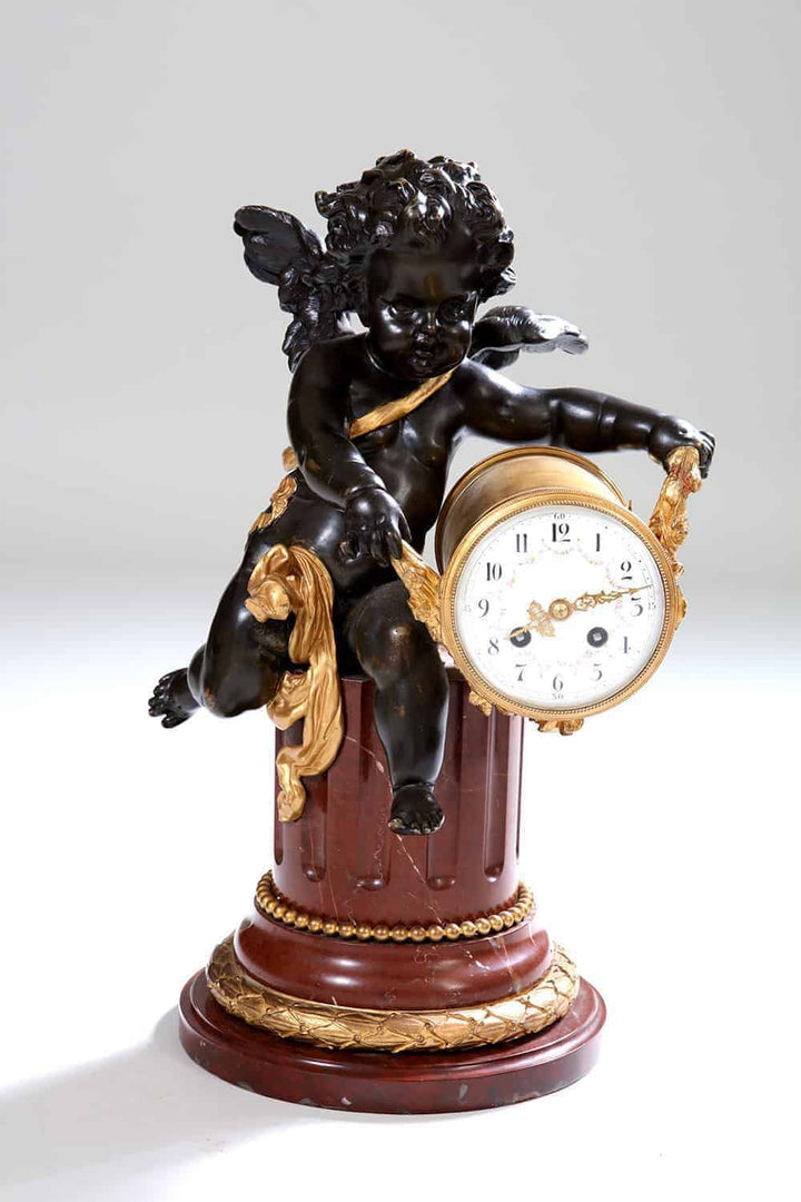Gilt bronze cherub clock on rouge marble column with gilt accents by Nicholas Wells Antiques