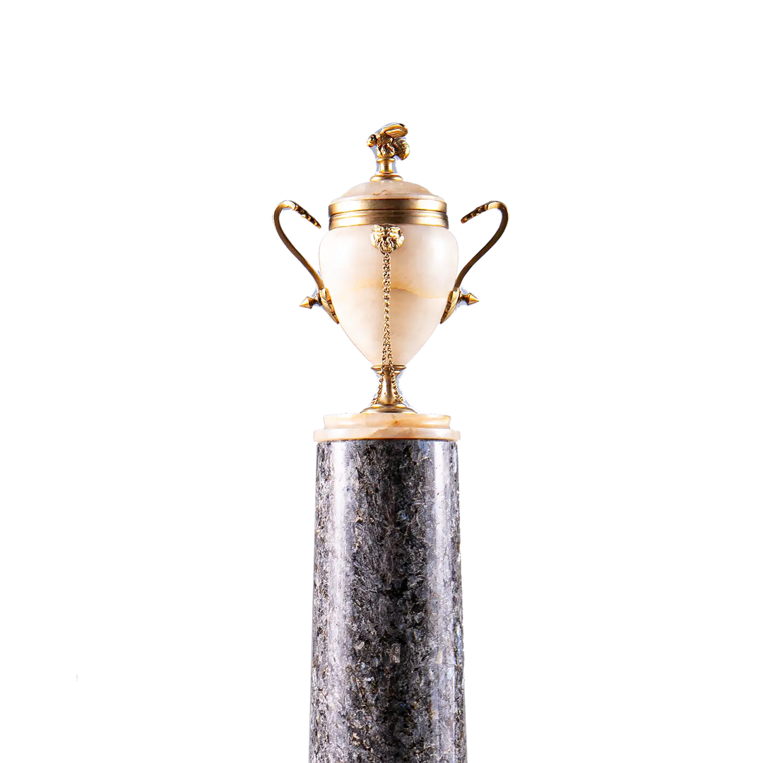 Neoclassical Urn on Granite Pedestal with alabaster body, gilded bronze handles, lion’s heads, bee finial, on dark granite base.