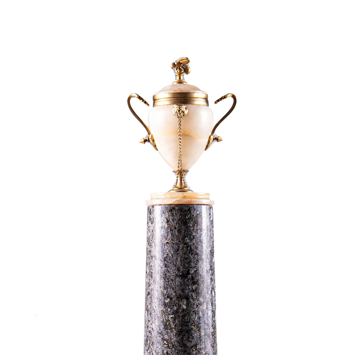 Neoclassical Urn on Granite Pedestal with alabaster body, gilded bronze handles, lion’s heads, bee finial, on dark granite base.