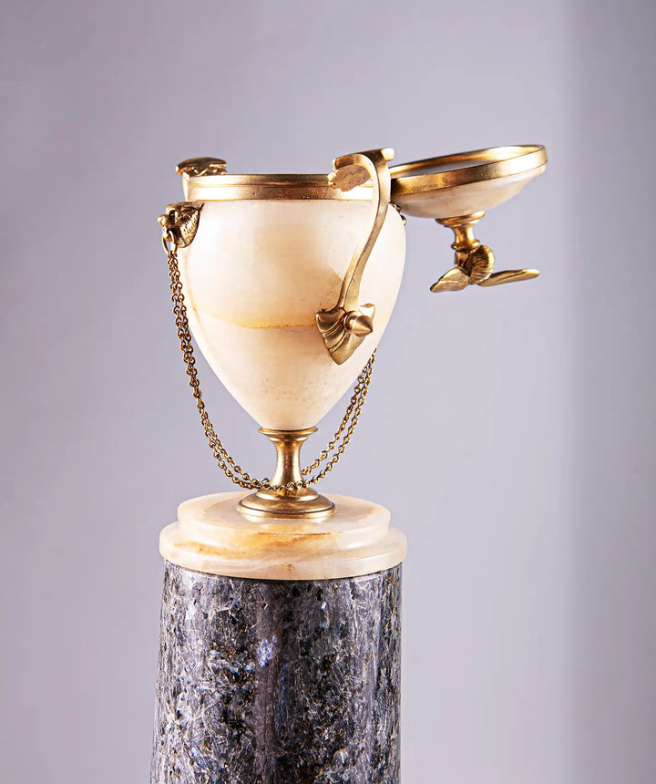 Neoclassical Urn on Granite Pedestal with alabaster body, gilded bronze handles, lion’s head details, and bee finial.
