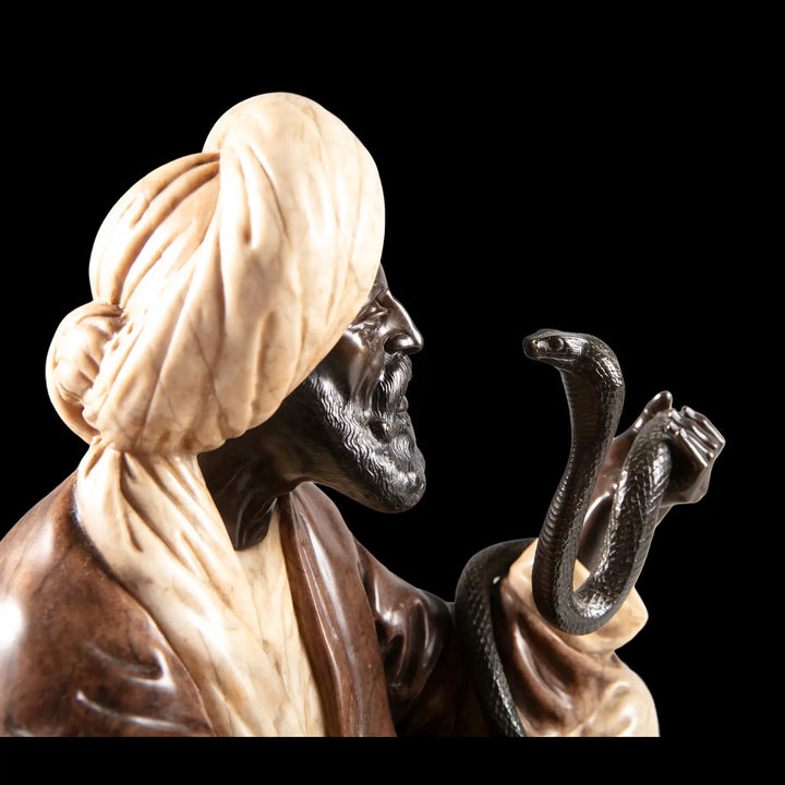 Two-tone onyx and alabaster sculpture of a seated snake charmer by Rudolf Franke-Nautschütz, offered by Nicholas Wells Antiques