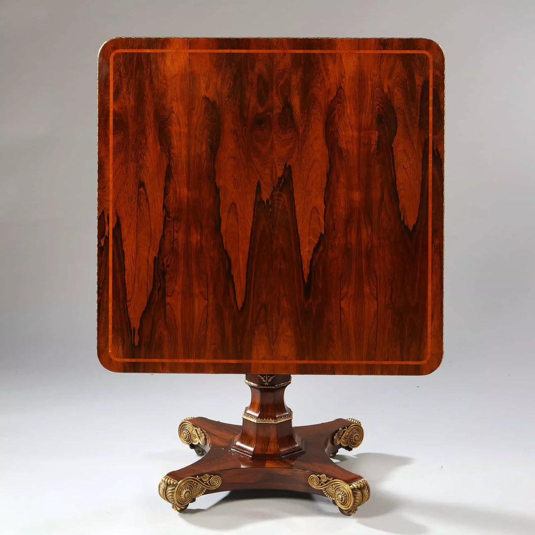 Regency Rosewood Square Center Table with bookmatched veneers, gilt metal edge, and ornate cast bronze feet, circa 1810.