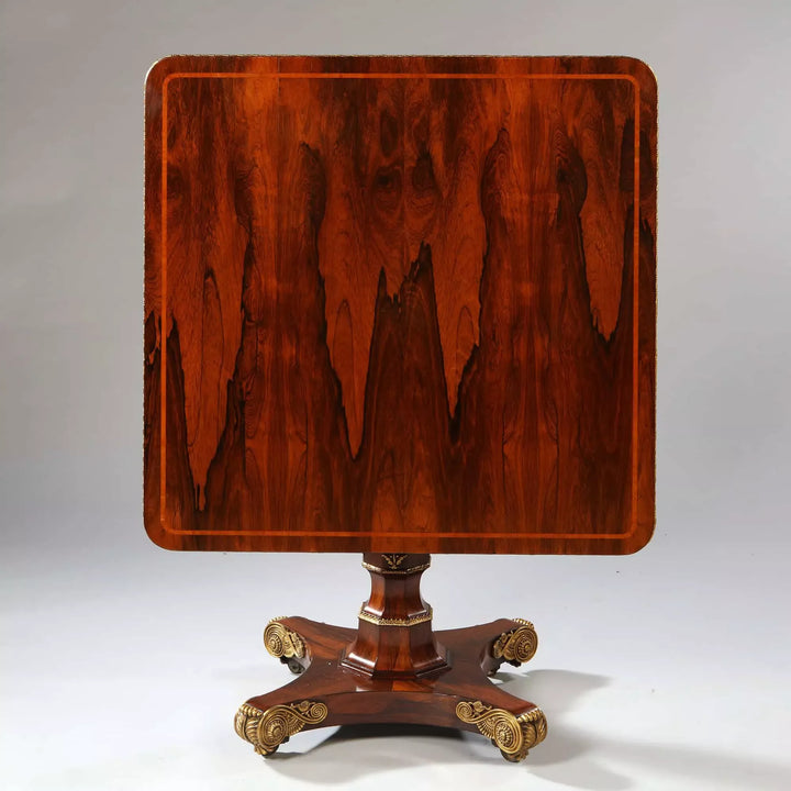 Regency Rosewood Square Center Table with bookmatched veneers, gilt metal edge, and ornate cast bronze feet, circa 1810.