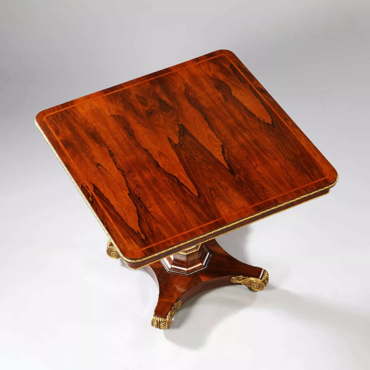 Regency Rosewood Square Center Table with bookmatched veneer, gilt metal edge, faceted base, and bronze feet, circa 1810.