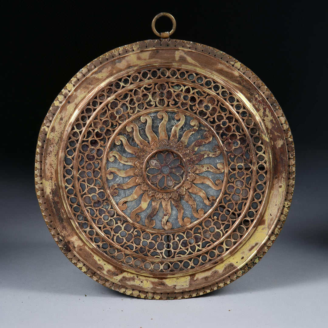 Group of nine pierced gilt copper mirrored chakras by Collection EE20 with intricate circular patterns and aged patina