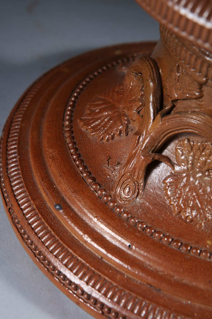 Close-up of brown glazed stoneware base with intricate leaf and vine details by Collection EE20