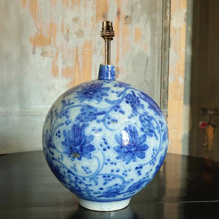 Spanish Blue and White Table Lamp with a spherical vase design featuring blue floral patterns on white ceramic.