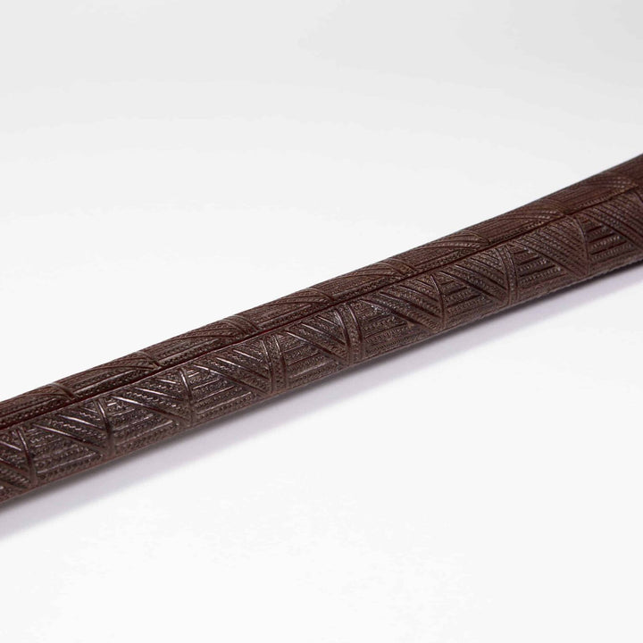 Tongan War Club made of ironwood with geometric patterns and shark teeth incisions from 18th century Tonga.
