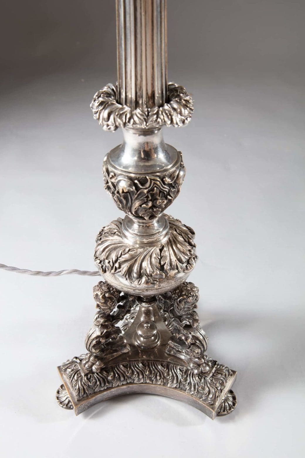 Pair Of Large Silvered Column Lamps with intricate Neo Renaissance grotesque silver plate detailing on column base.