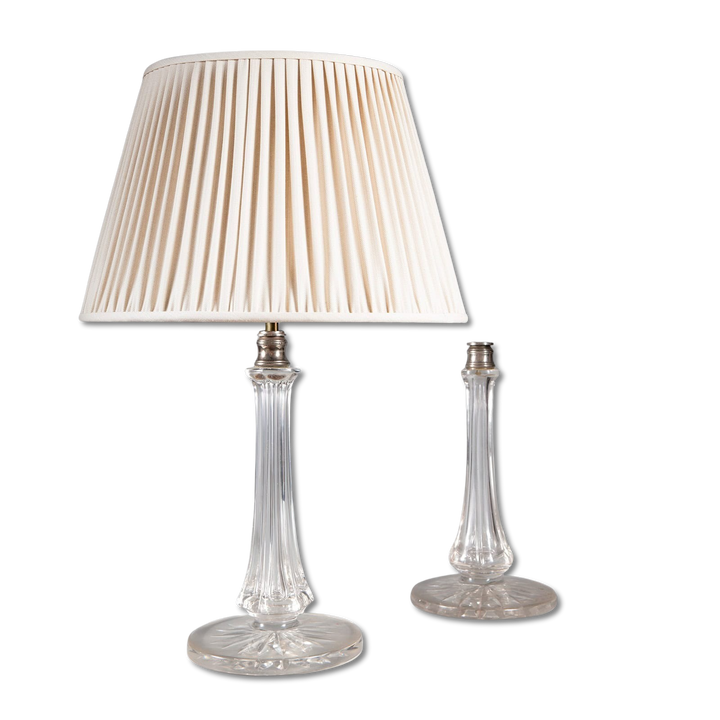 Pair of Clear Glass Column Lamps by Osler featuring clear glass bases with silvered metal fittings, one with a pleated cream shade.
