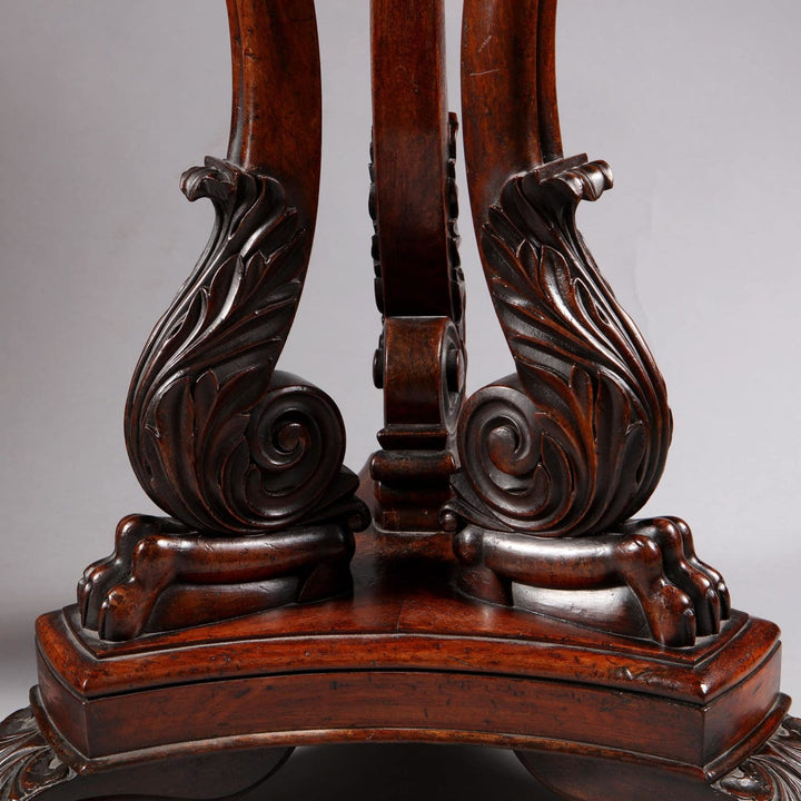 Detailed carved wooden base of the Regency Specimen Marble Centre Table showing intricate scroll patterns.