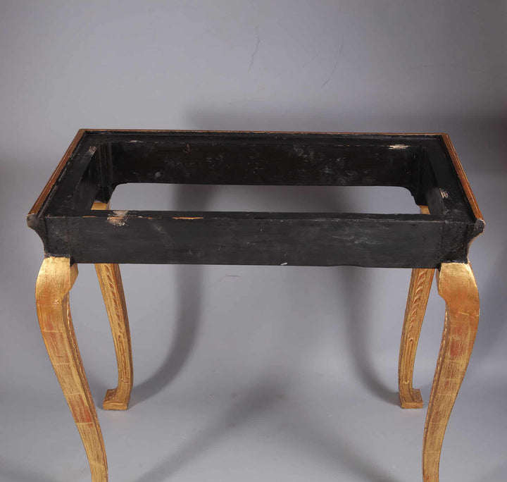 George I Gilt Gesso Side Table with carved gilt legs and black frame, missing its marble top, 19th Century.