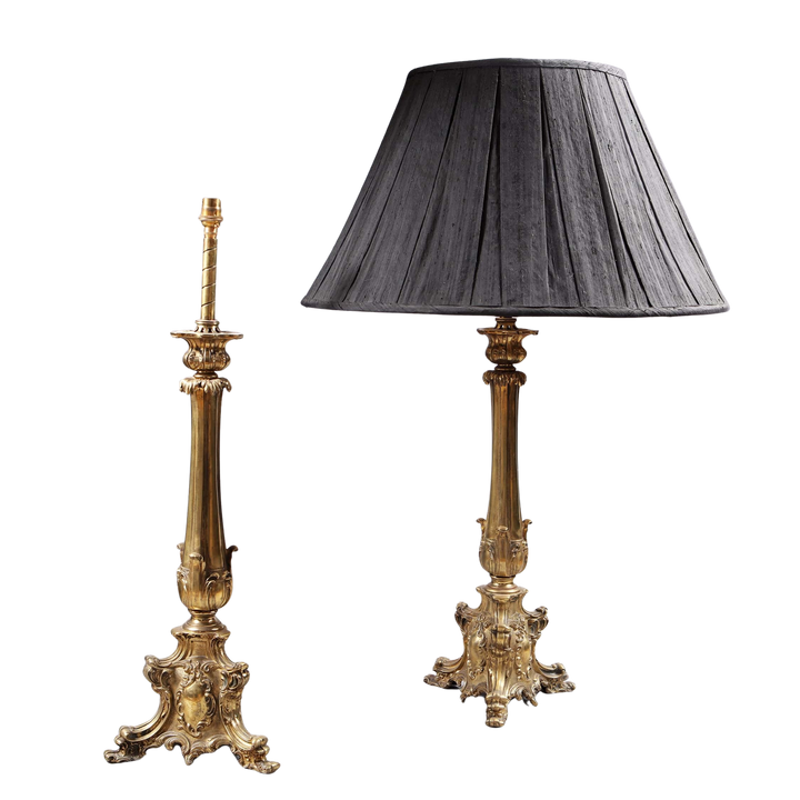 Pair of Brass Column Lamps with ornate bases, one with a black pleated lampshade, vintage elegant design.