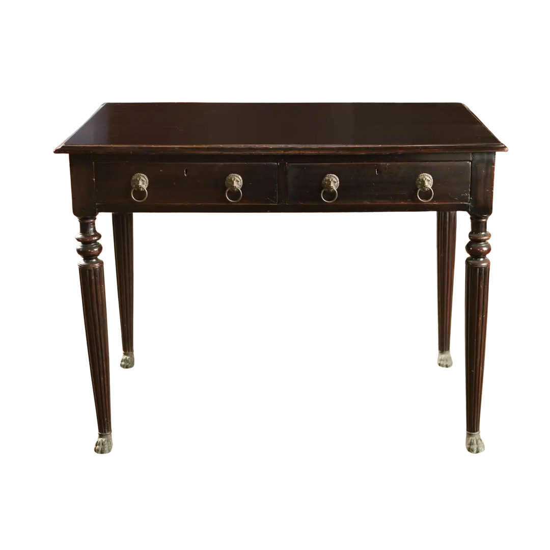 Anglo Indian Ebonised Writing Table with two drawers, fluted legs, lion mask handles, and brass paw feet from 1860.