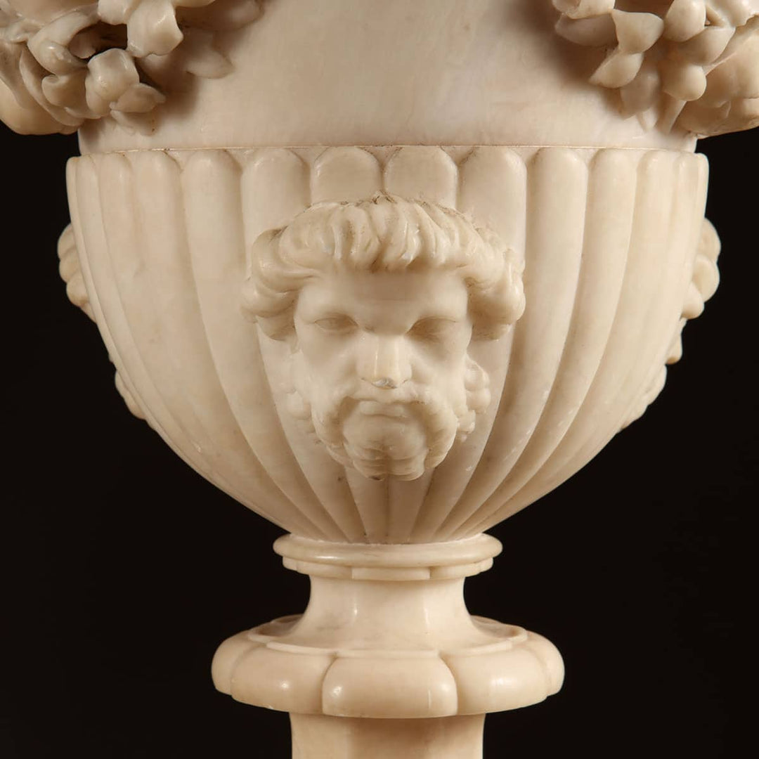 Close-up of carved alabaster vase with classical male mask on pedestal from Collection CK20 floor lamps