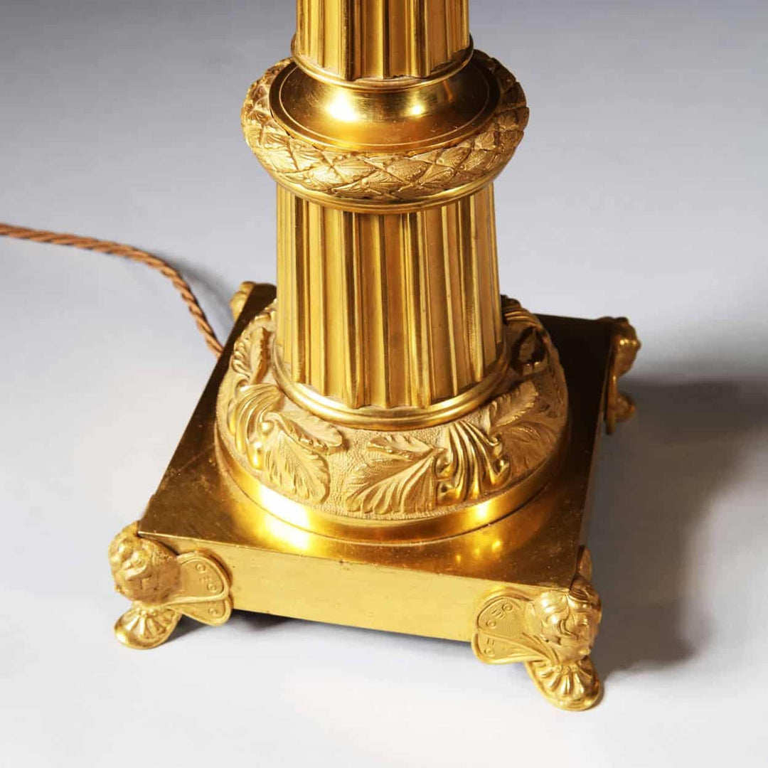 Pair Of French Gilt Bronze And Tole Antique Gold Column Table Lamps with detailed ornate base and fluted column design.