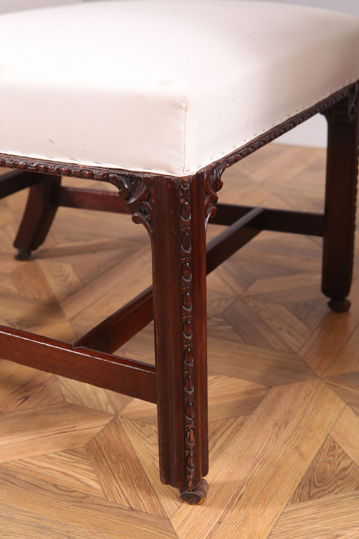 Close-up of George III mahogany side chair leg with carved details and white upholstered seat by Collection CK20