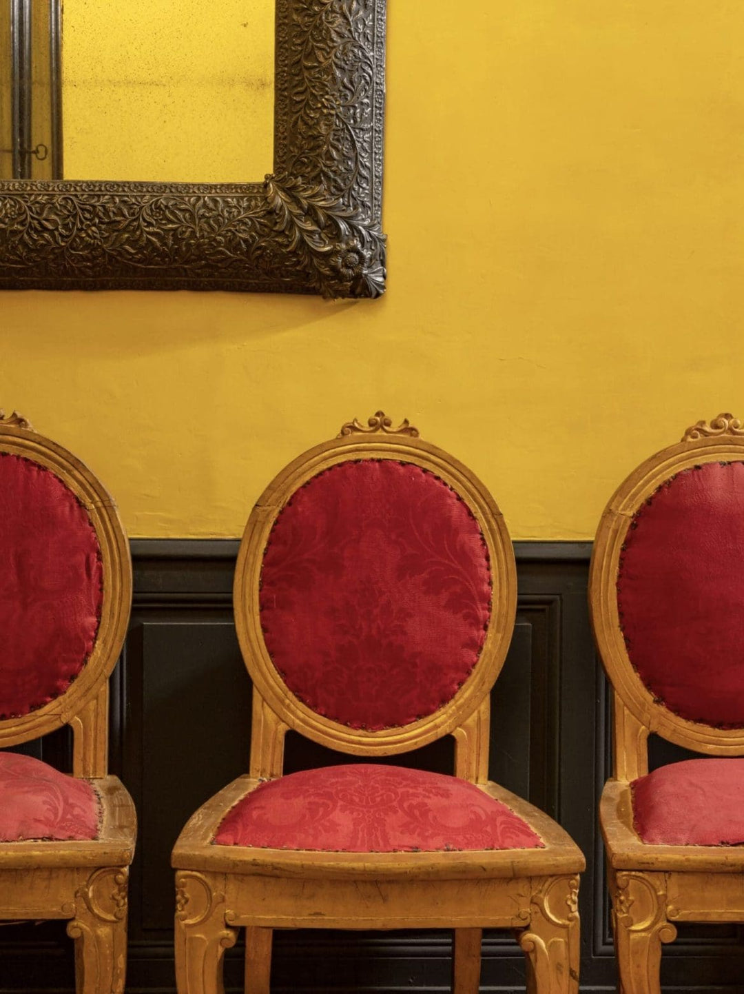 Three antique Anglo Indian side chairs with red damask upholstery from Collection EE30 displayed against yellow wall