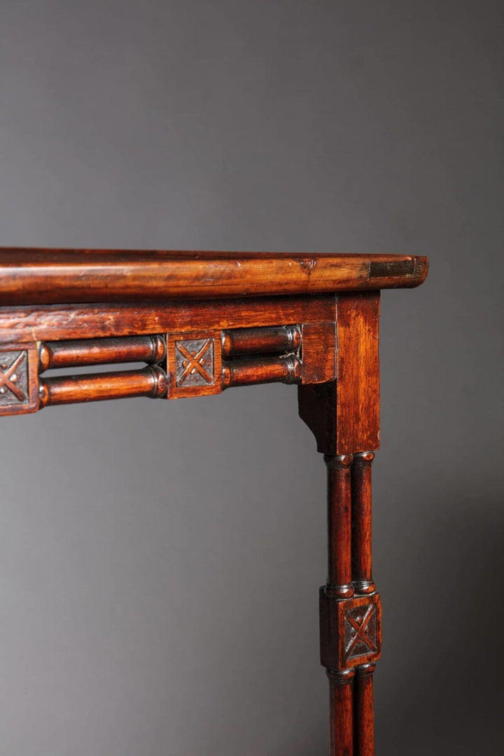 A close-up of a George III mahogany silver table leg with carved cluster columns and cruciform ornaments.
