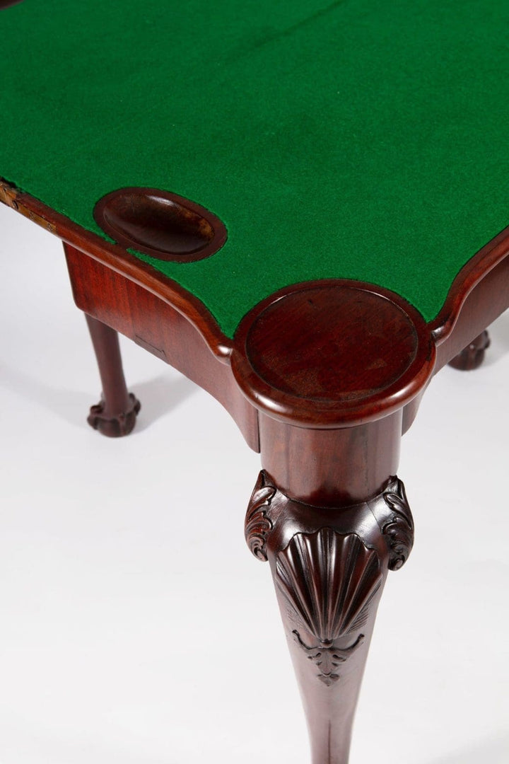 George III Mahogany Card Table with scallop shell carvings, ball and claw feet, and green baize folding top.