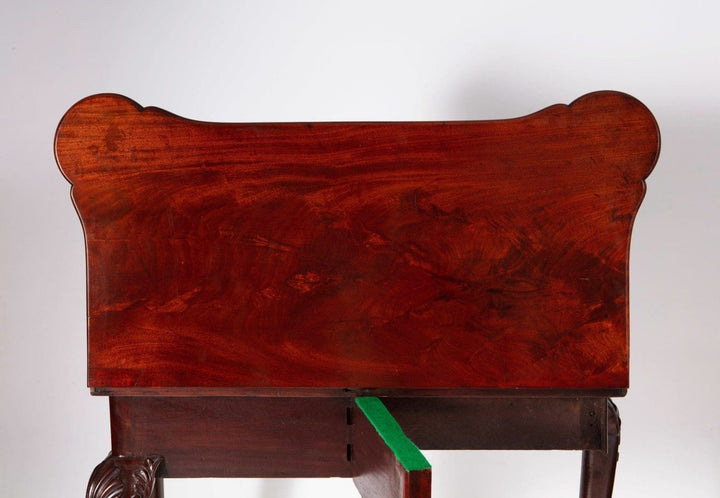 George III Mahogany Card Table with rich mahogany finish, carved cabriole legs, and folding top opening to baize interior.