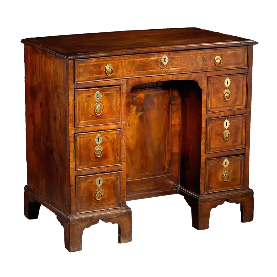 George I Walnut Kneehole Desk with brass handles, feather banding, kneehole cupboard, and ogee bracket feet circa 1715.