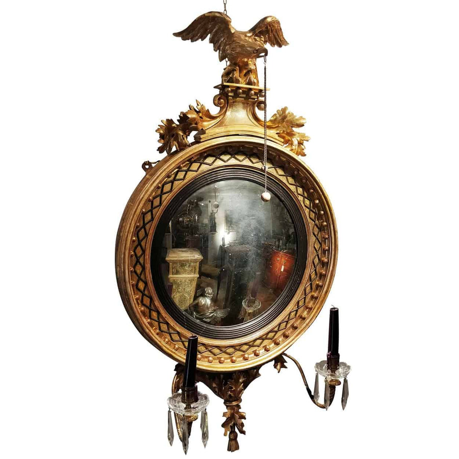 English Regency Giltwood Convex Mirror with two-tone gilding, eagle crest, candle arms, and original mirror plate, circa 1810.