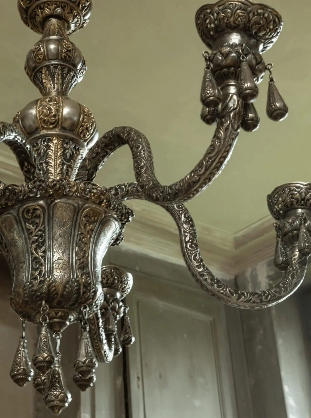 Close-up of ornate Repoussรฉ silver six arm Indian chandelier from Collection EE20 with detailed relief work