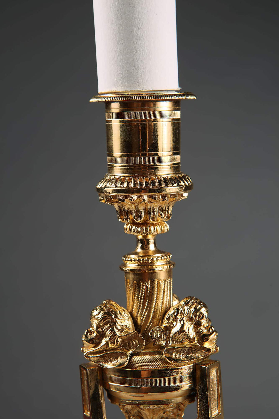 Pair of French Gilt Bronze Neo Classical Candlestick Table Lamps with intricate lion head details and white candle.