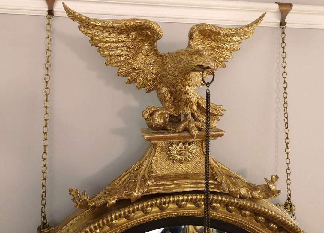 Fine English 19th Century Regency Convex Mirror with gilt eagle crest and ornate decorative frame details.