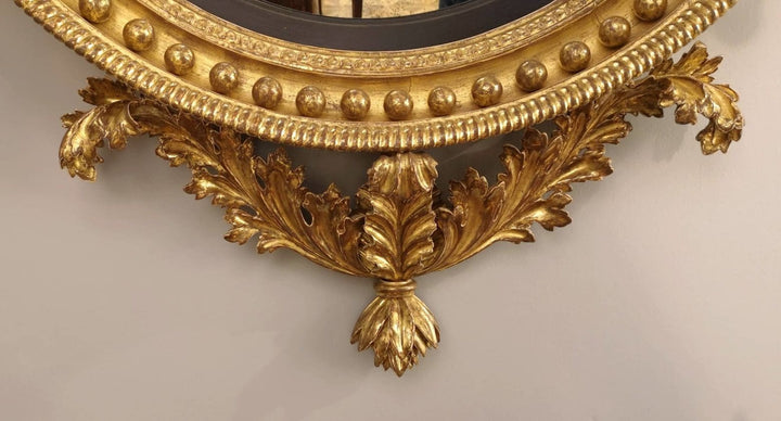 Fine English 19th Century Regency Convex Mirror with ornate giltwood frame, acanthus leaves, and decorative gilt wood balls.