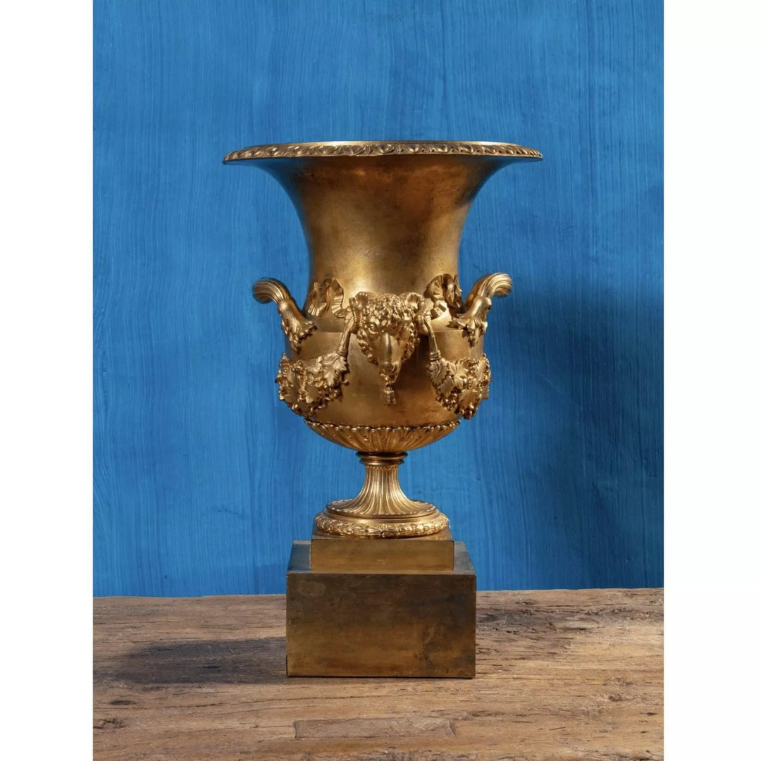 Restauration gilt-bronze vase with rams’ heads and grapevine swags on a tall square plinth by Collection EE20