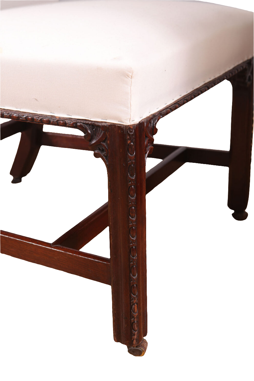 Close-up of a George III mahogany side chair leg with detailed carving and white upholstery by Collection CK20