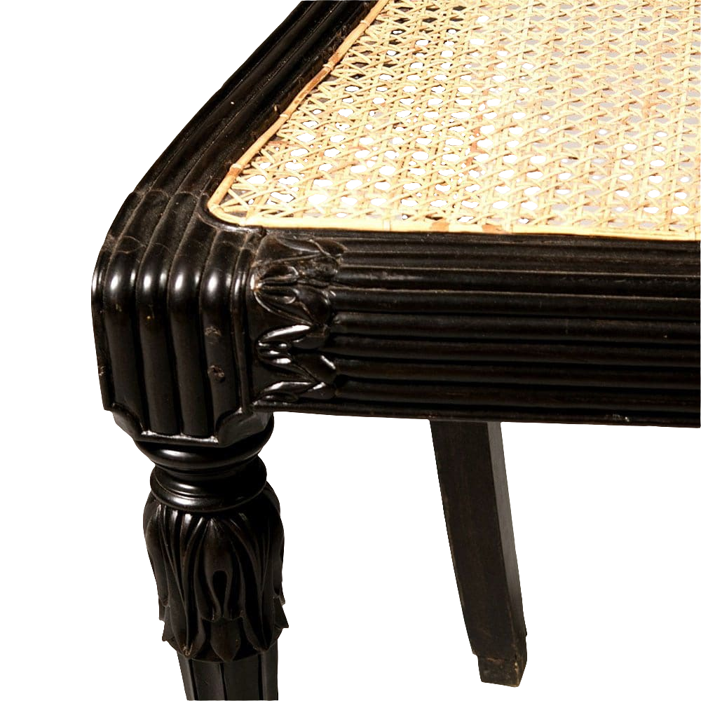 Close-up of ebony corner and caned seat of an Anglo-Indian side chair from Collection EE30 with detailed foliate carvings