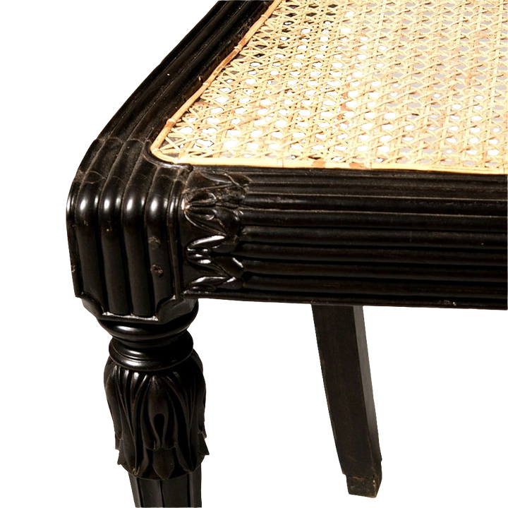 Close-up of ebony corner and caned seat of an Anglo-Indian side chair from Collection EE30 with detailed foliate carvings
